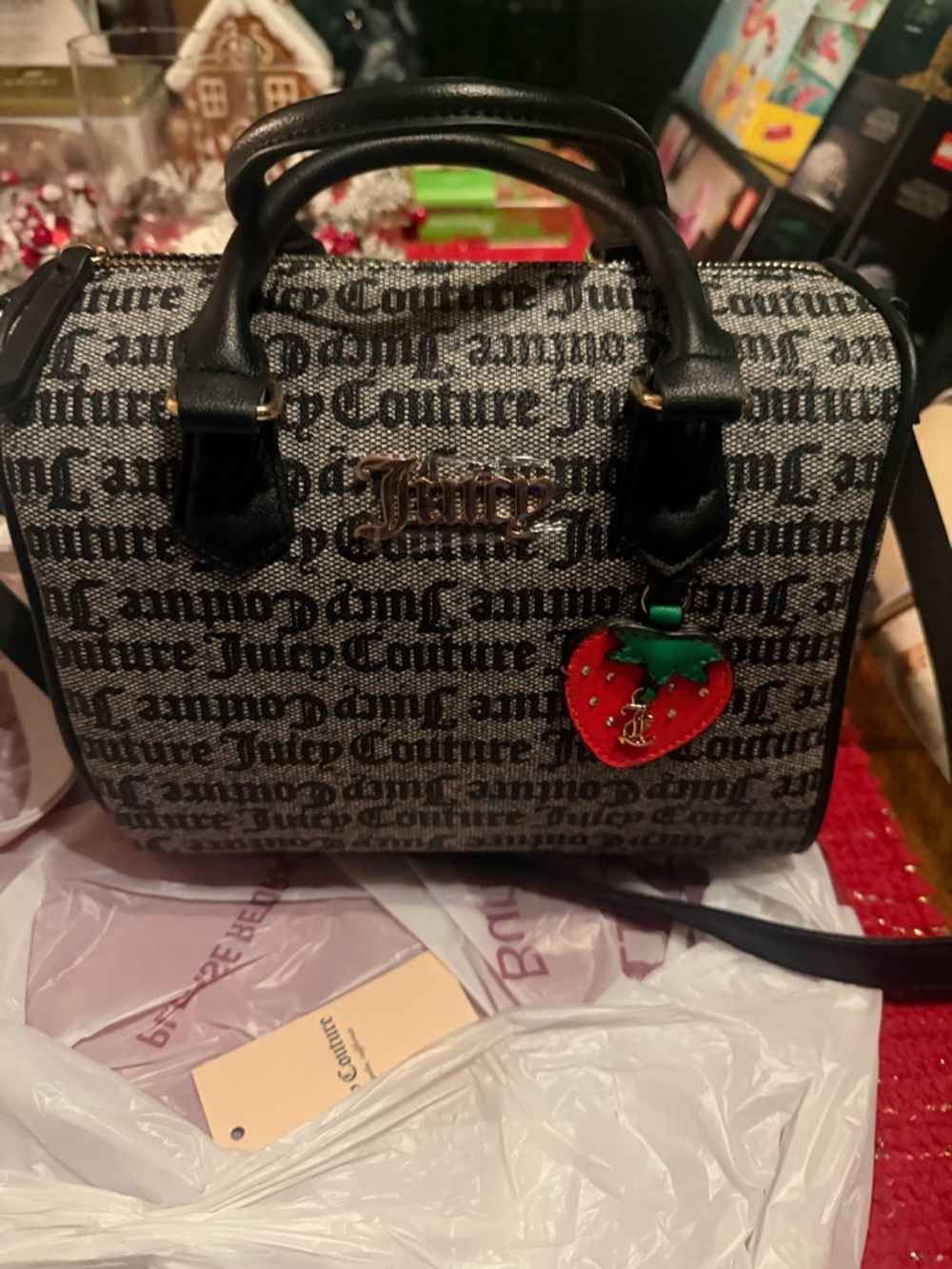Juicy Couture Black Logo Satchel with Red Strawberry Charm Accent.